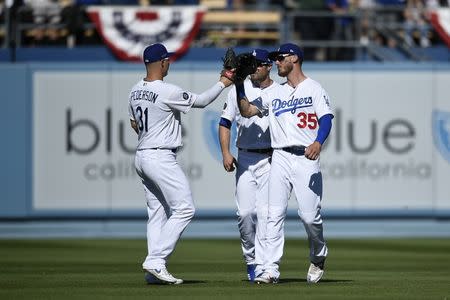 Mar 28, 2019; Los Angeles, CA, USA; Los Angeles Dodgers right fielder Cody Bellinger (35) celebrates with left fielder Joc Pederson (31) after the game as center fielder A.J. Pollock (11) looks on against the Arizona Diamondbacks at Dodger Stadium. Mandatory Credit: Kelvin Kuo-USA TODAY Sports