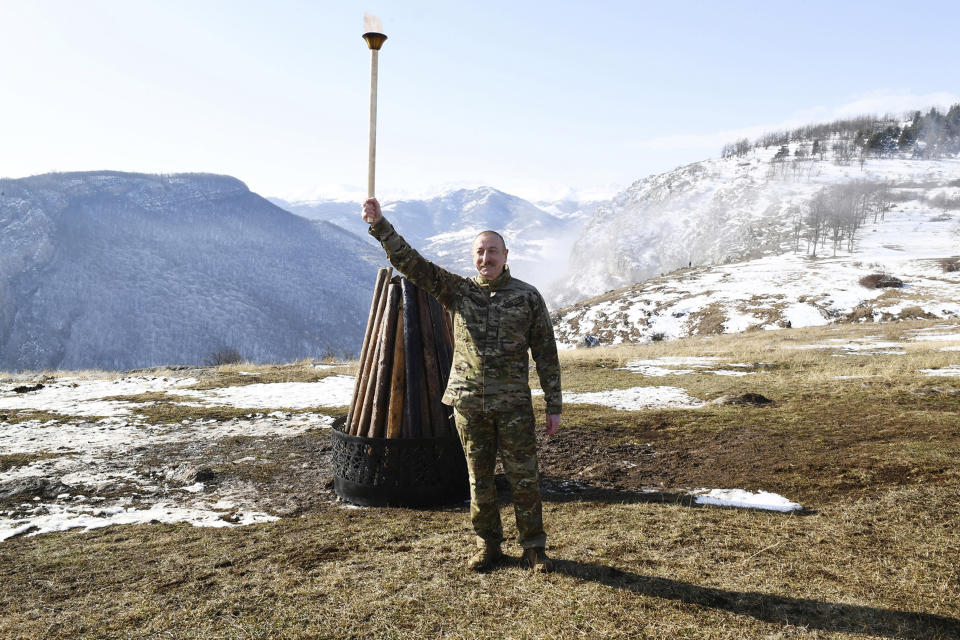 This photo provided by Azerbaijan's Presidential Press Office on Saturday, March 20, 2021, shows Azerbaijani President Ilham Aliyev celebrates Novruz Bayramı, a traditional holiday which celebrates the New Year and the coming of Spring outside Shusha, Azerbaijan. Aliyev marked the Nowruz holiday by lighting a ceremonial fire outside Shusha, a culturally revered city that Azerbaijan took from Armenian forces in last autumn's war. Shusha, a center of Azeri culture for centuries, came under Armenian control in 1992 in fighting over the separatist Nagorno-Karabakh region. (Vugar Amrullaev/Azerbaijani Presidential Press Office via AP)