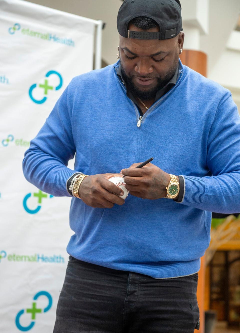 David Ortiz signs a baseball during his visit Monday to the Natick Mall, Oct. 10, 2022.