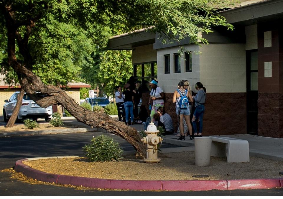 Women standing outside a building near a tree