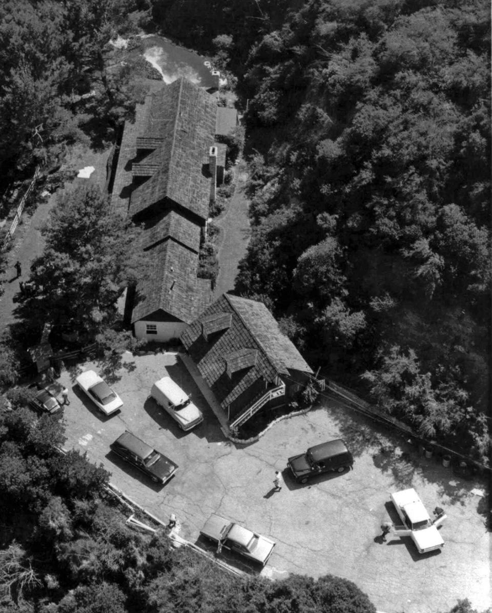 FILE - This Aug. 9, 1969 file photo shows the home of actress Sharon Tate and director Roman Polanski, after Tate and four others were murdered Aug. 8-9, 1969. One body is under a sheet at upper left; another is in the car at lower right. Fifty years ago Charles Manson dispatched a group of disaffected young followers on a two-night killing rampage that terrorized Los Angeles and, in the years since, has come to represent the face of evil. (AP Photo/File)