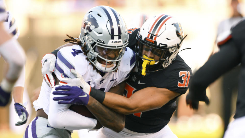 Oklahoma State safety Kolby Harvell-Peel (31) wraps up Kansas State wide receiver Malik Knowles (4) during the first half of an NCAA college football game Saturday, Sept. 25, 2021, in Stillwater, Okla. (AP Photo/Brody Schmidt)