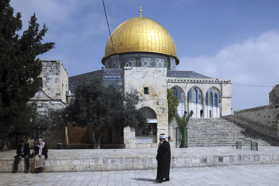 A Palestinian walks in front of the Dome of the Rock in Jerusalem, Sunday, March 15, 2020. Israel imposed sweeping travel and quarantine measures more than a week ago but has seen its number of confirmed coronavirus cases double in recent days, to around 200. On Saturday, the government said restaurants, malls, cinemas, gyms and daycare centers would close. (AP Photo/Mahmoud Illean)