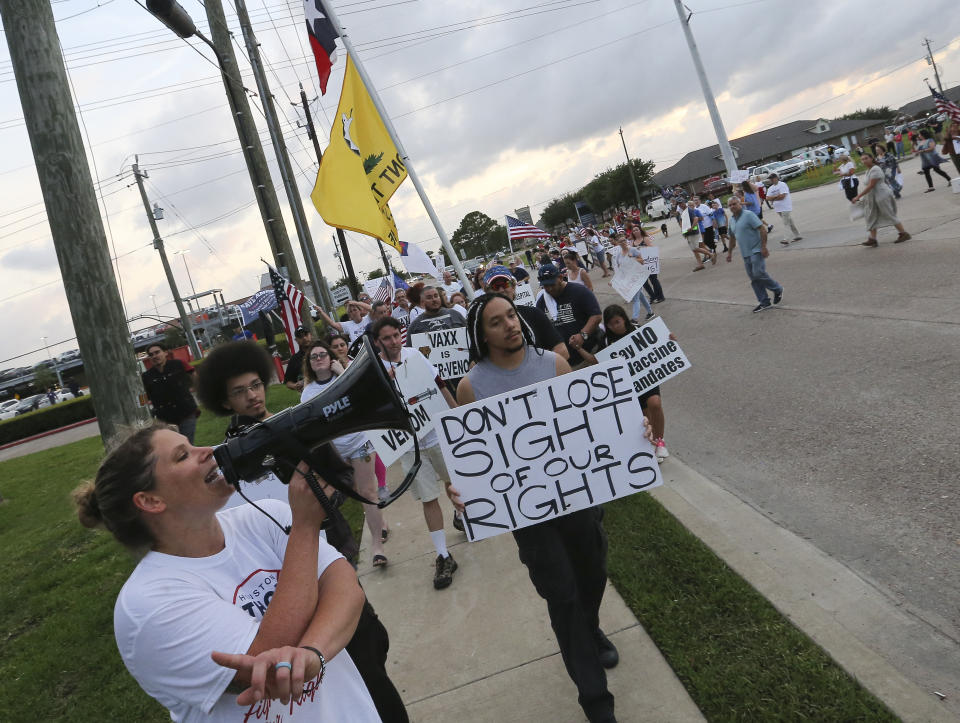 Jennifer Bridges, left, leads people marching past protest Houston Methodist Baytown Hospital to protest against the hospital system's rule of firing any employee who is not immunized by Monday, June 7, 2021, in Baytown, Texas. Public and Houston Methodist staff who have refused the COVID-19 vaccine so far participated a gathering and march. (Yi-Chin Lee/Houston Chronicle via AP)