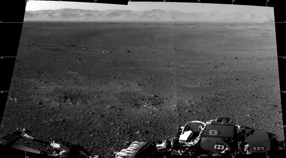 These are the first two full-resolution images of the Martian surface from the Navigation cameras on NASA's Curiosity rover, which are located on the rover's "head" or mast. The rim of Gale Crater can be seen in the distance beyond the pebbly g