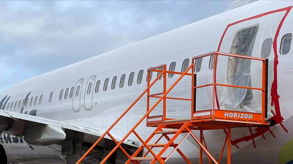 Plastic covers the exterior of the fuselage plug area of Alaska Airlines Flight 1282 Boeing 737 Max after the door plug blew out on a January 5 flight. - NTSB/Handout/Getty Images