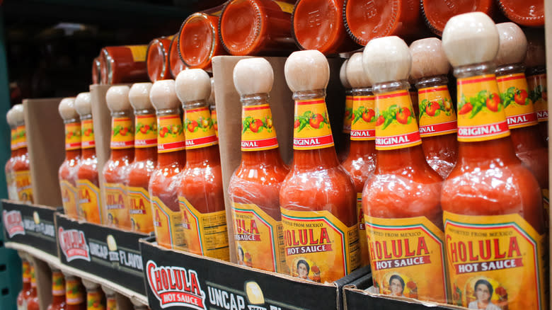 Row of Cholula hoy sauce stacked on grocery shelf