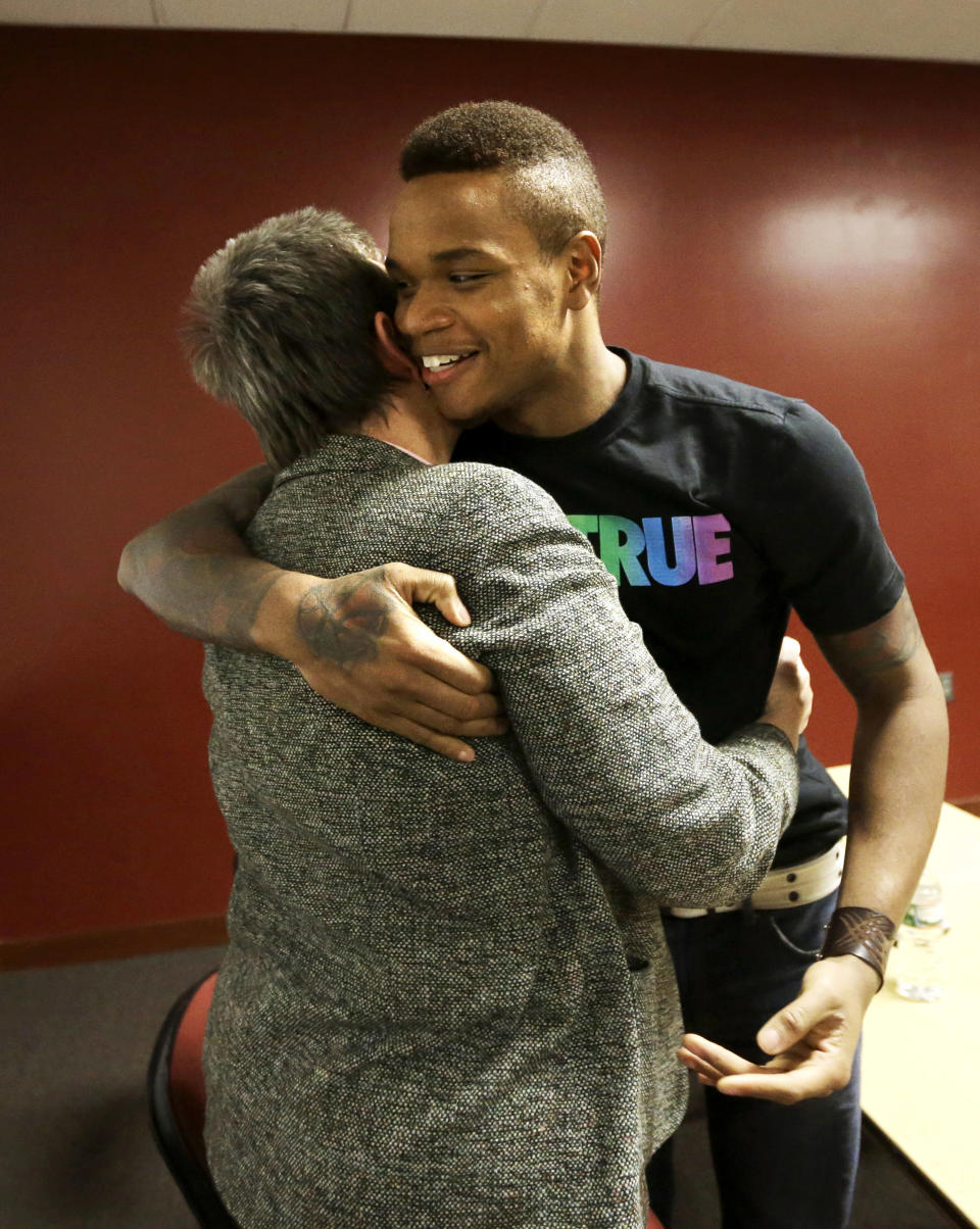 University of Massachusetts basketball guard Derrick Gordon hugs UMass professor emeritus Pat Griffin after speaking to reporters on the school's campus, Wednesday, April 9, 2014, in Amherst, Mass. Gordon has become the first openly gay player in Division I men's basketball. Griffin teaches lesbian, gay, bisexual, and transgender issues. (AP Photo/Steven Senne)