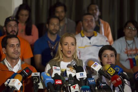 Lilian Tintori (C), wife of jailed Venezuelan opposition leader Leopoldo Lopez, reads out a letter from her husband during a news conference next to Patricia Ceballos (R), wife of jailed former mayor Daniel Ceballos, in Caracas June 23, 2015. REUTERS/Marco Bello