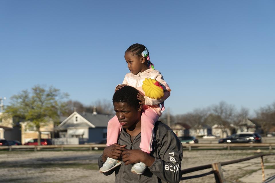 Theon Davis, 21, plays with his 2-year-old daughter Harmony Davis at a park near their home Wednesday, April 12, 2023, in Chicago. Davis lives with his mother, Donna Weatherly, in the Belmont Cragin neighborhood, about five miles from the gym. He uses his bike and public transportation to get to the fieldhouse and his job, which is five miles in a different direction from home. Weatherly says Harmony stays with them three to five nights a week. It’s not easy, but they manage. (AP Photo/Erin Hooley)