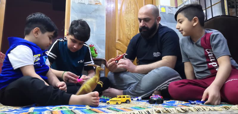 Local worker Mohammed Haider plays with his children at his home in Basra