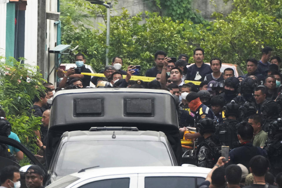 A a senior police officer, partly seen at center right on a stretcher, is carried on to an ambulance in Bangkok, Thailand, Wednesday, March 15, 2023. Thai police on Wednesday detained the senior police officer who fired multiple gunshots from his home in Bangkok, ending a standoff of over 24 hours after his colleagues tried to take him to be treated for mental illness. (AP Photo/Sakchai Lalit)