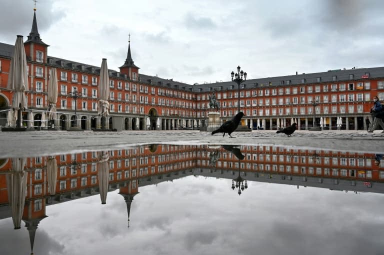 (ARCHIVES) Une personne traverse la Plaza Mayor déserte, le 21 avril 2020, lors du premier confinement décrété en Espagne, alors que la capitale espagnole est frappée à nouveau par un confinement partiel, comme d'autres villes et régions, face à la reprise de l'épidémie de coronavirus (photo d'illustration) - Gabriel BOUYS © 2019 AFP