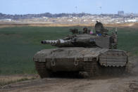 An Israeli Defense Forces tank drives away from the Gaza Strip, as seen from southern Israel, Monday, May 6, 2024. (AP Photo/Tsafrir Abayov)