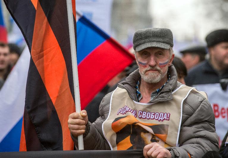 Wearing wests with portraits of President Vladimir Putin under a motto "Motherland and Freedom!" an elderly pro-Kremlin activist takes part in a rally in Moscow, on March 2, 2014