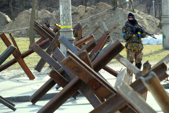 An armed soldier stands guard at a roadblock.