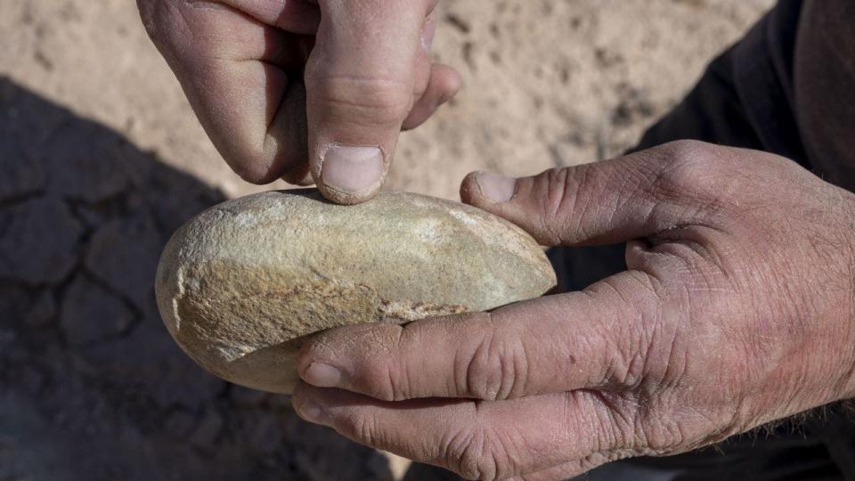 Hands holding ground stone