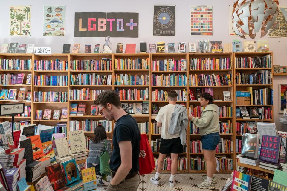 People browse books on tables and high shelves.