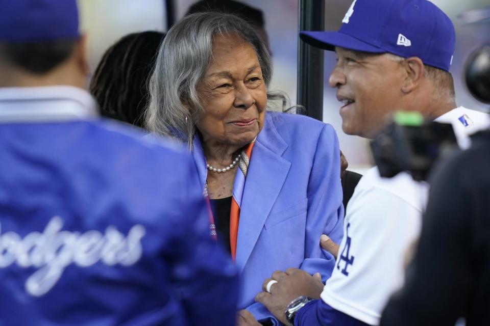 Rachel Robinson, esposa de Jackie Robinson, habla con el manager de los Dodgers, Dave Roberts, antes del partido del viernes en el Dodger Stadium.