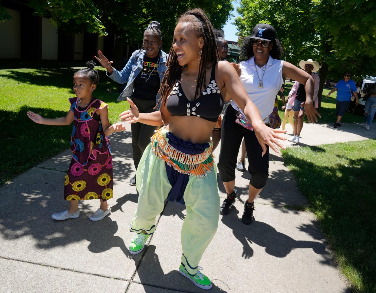 Dancer Eboni Edwards, an Ohio State student from New Jersey who was performing with the Thiossane Institute, leads festival goers out into the street at the opening of the first Juneteenth on the Ave celebration on June 18, 2022 along Mount Vernon Avenue in Columbus' historic Bronzeville neighborhood.