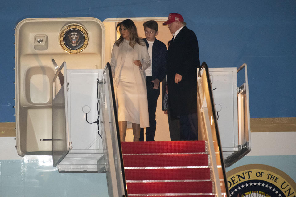 El president Donald Trump, la Primera Dama Melania Trump y el hijo de la pareja, Baron Trump, salen del avión Air Force One el 1 de diciembre de 2019, tras regresar de Mar-a-Lago en Florida. Melania Trump lleva el abrigo criticado por el diario The Washington Post (AP /Kevin Wolf)