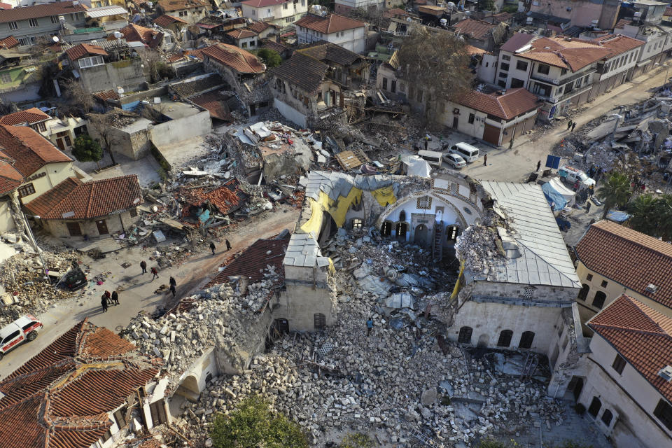 Turkish citizens pass next the historic Habib Najjar mosque which destroyed during the devastated earthquake, in the old city of Antakya, Turkey, Saturday, Feb. 11, 2023. Antakya, known as Antioch in ancient times, has been destroyed many times by earthquakes. It was destroyed yet again by an earthquake earlier this month, and residents are wondering if its ancient glories will ever come back. (AP Photo/Hussein Malla)