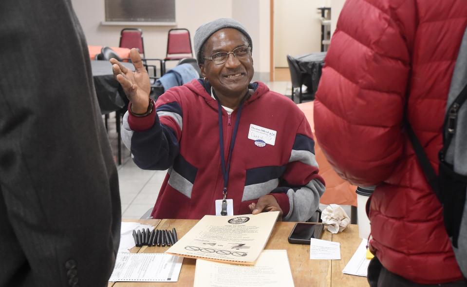 Poll worker Darryl Lyons, 62, directs two voters on their next steps at Joseph A. Schmid Towers in Erie on Election Day on Tuesday.