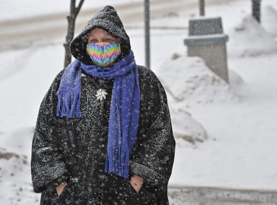 Girard resident Diane Phelps walks along Main Street in Girard during a morning snowfall on Feb. 15, 2021. Snowfall is expected in the Erie region beginning Monday and tapering off after Tuesday.