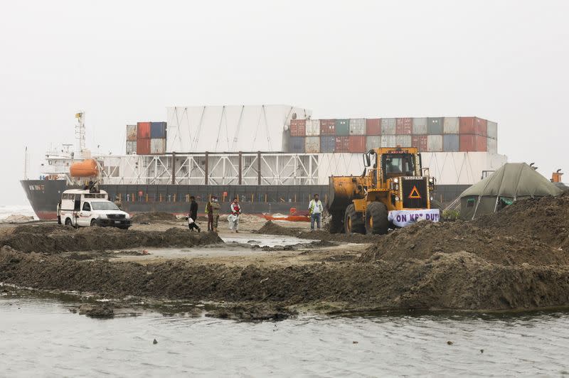 A wheel loader clears the ground near stranded cargo ship MV Heng Tong 77 at Sea View beach in Karachi