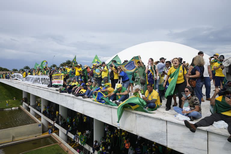 Manifestantes partidarios del expresidente de Brasil Jair Bolsonaro en el techo del edificio del Congreso Nacional después de irrumpir en el recinto, el 8 de enero de 2023, en Brasilia. (AP Foto/Eraldo Peres, Archivo)