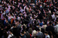 Travelers wearing face masks to protect against COVID-19 line up for trains at a station in Guangzhou in southern China's Guangdong Province, Friday, Jan. 28, 2022. Chinese are traveling to their hometowns for the Lunar New Year, the country's biggest family holiday, despite a government plea to stay where they are as Beijing tries to contain coronavirus outbreaks. (Chinatopix via AP)