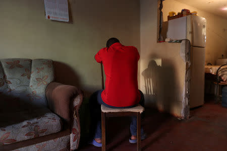 Haitian migrant Stephane, 19, hides his face as he poses for a picture at a house in the Cherro Chuno neighbourhood, near the Chilean and Peruvian border, in Arica, Chile, November 18, 2018. REUTERS/Ivan Alvarado