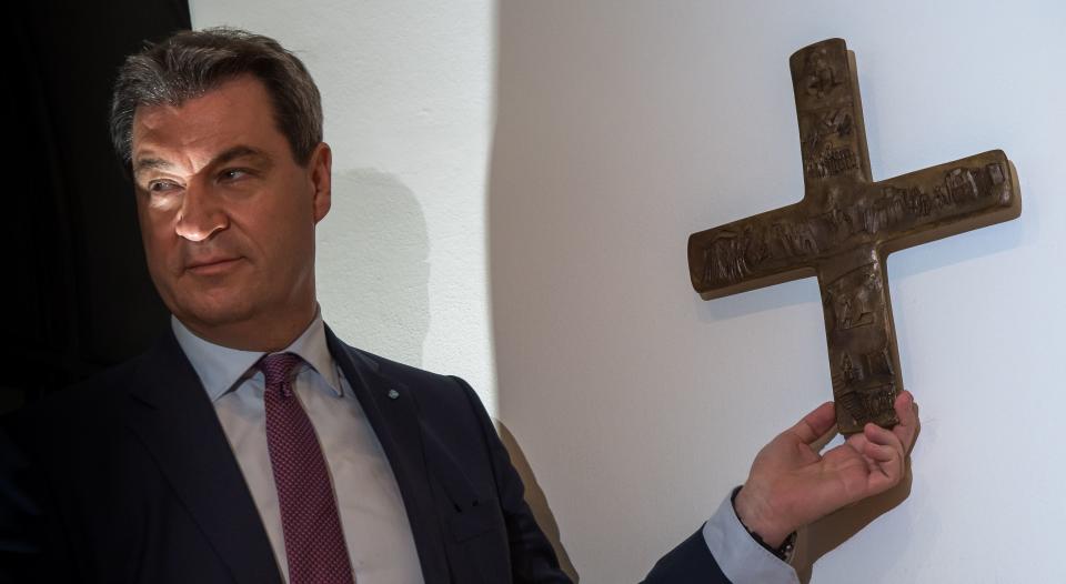 Markus Söder mit einem Kreuz, wie es bald in allen bayerischen Behörden hängen soll. (Bild: dpa)