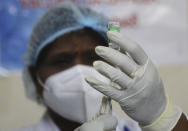 A health worker prepares to administer COVID-19 vaccine to a hospital staff at a government Hospital in Hyderabad, India, Saturday, Jan. 16, 2021. India started inoculating health workers Saturday in what is likely the world's largest COVID-19 vaccination campaign, joining the ranks of wealthier nations where the effort is already well underway. (AP Photo/Mahesh Kumar A.)