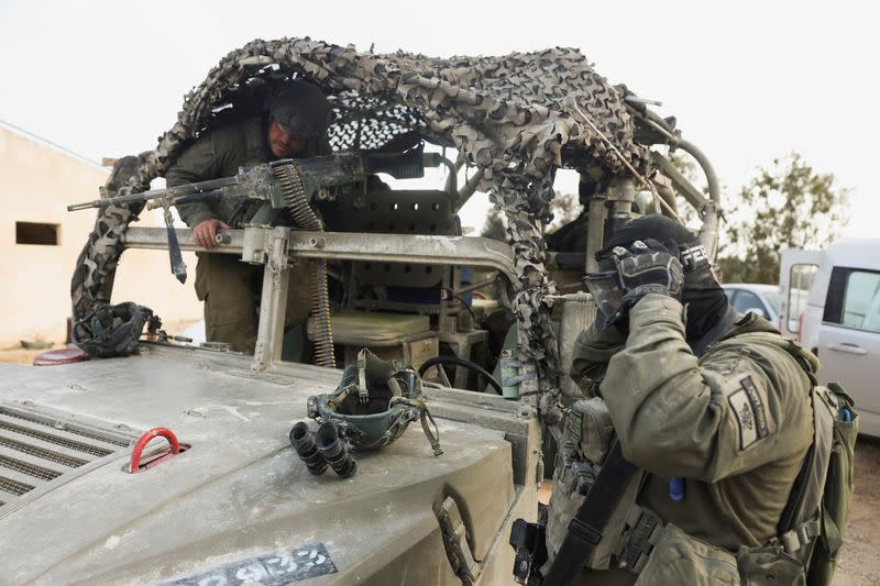 Israeli military vehicles are parked near the Israel-Gaza border