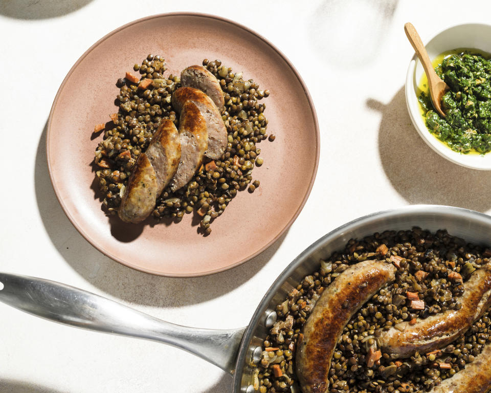 This image released by Milk Street shows a recipe for Braised Sausages with Lentils. (Milk Street via AP)