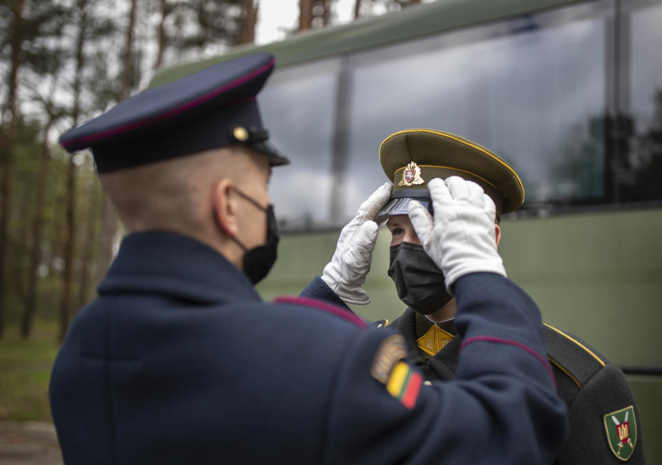 Lithuanian soldiers of the honour guard, wearing face masks to prevent the spread of coronavirus, prepare to attend a ceremony marking the 76th anniversary of the end of World War II at the Paneriai memorial, Vilnius, Lithuania, Saturday, May 8, 2021. Victory in Europe Day is celebrated on May 8 to mark the date in 1945 that WWII ended in Europe following Nazi Germany's surrender of its armed forces. (AP Photo/Mindaugas Kulbis)