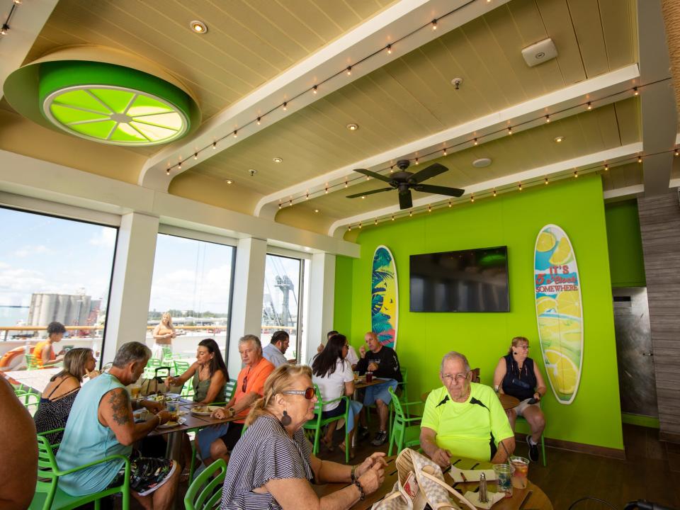 People sitting at tables in an open-aired seating area.