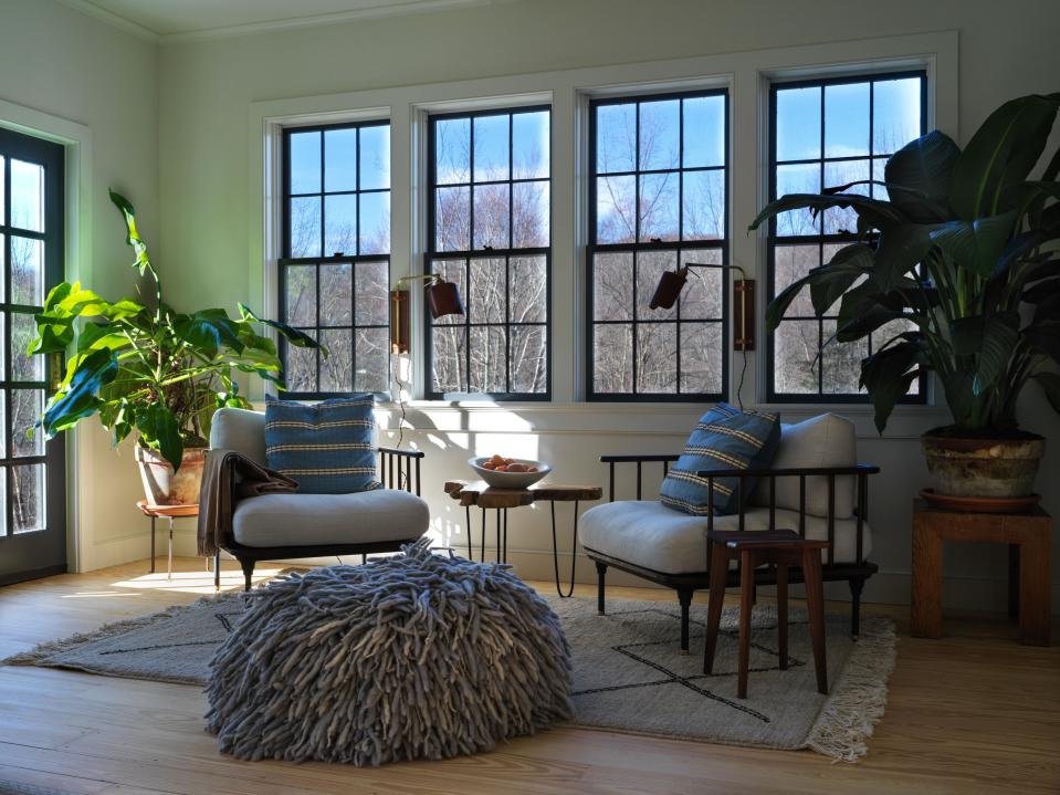 Rouse home chairs make for a cozy reading area at the far end of the living room; pouf from ZZ Driggs .