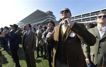 Racegoers react whilst watching a race at the Cheltenham Festival horse racing meet in Gloucestershire, western England March 14, 2014. REUTERS/Toby Melville