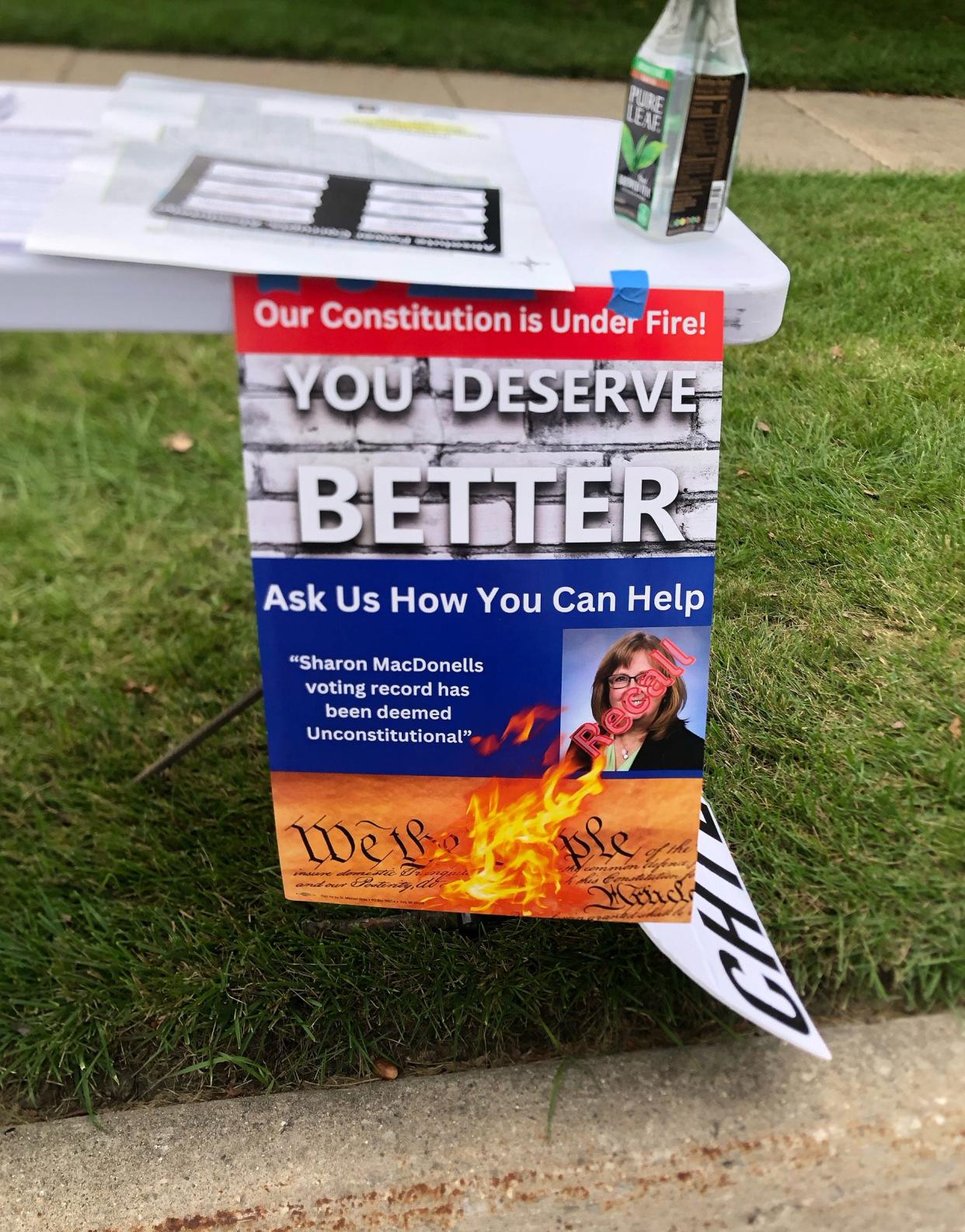 A recall campaign sign hangs from a petition circulator’s table outside the Troy Public Library on Sept 15, 2023.