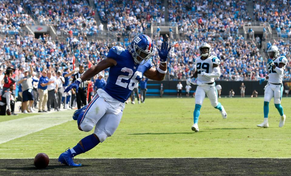 CHARLOTTE, NC - OCTOBER 07:  Saquon Barkley #26 of the New York Giants scores a 57-yard receiving touchdown from Odell Beckham Jr. #13 against the Carolina Panthers in the second quarter during their game at Bank of America Stadium on October 7, 2018 in Charlotte, North Carolina.  (Photo by Grant Halverson/Getty Images)