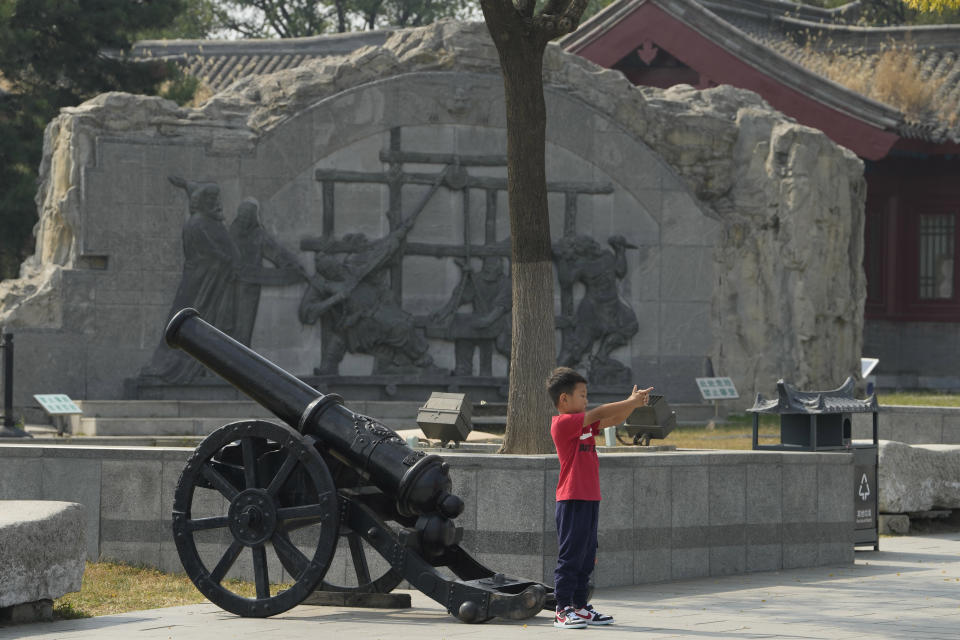 A child gestures holding a gun as he poses near a canon at Lugou Bridge also known as Marco Polo Bridge where it is generally remembered as the place from which an incident in 1937 started the Second Sino-Japanese War in Beijing, Tuesday, Sept. 27, 2022 Friend or foe? Or both? On the streets of Tokyo and Beijing, the ties between Japan and China remain complicated and often contradictory, 50 years after the two countries normalized relations as part of a process that brought communist China into the international fold. (AP Photo/Ng Han Guan)