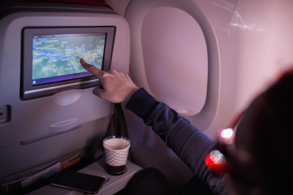 Young Woman Pointing on Map on Airplane Device Screen