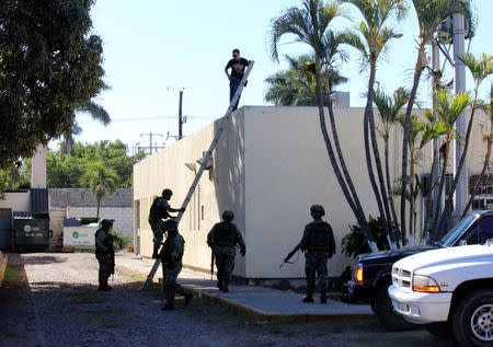 Soldiers stand guard at a crime scene where the body of a man, who witnesses said was tossed from a plane, landed on a hospital roof in Culiacan, in Mexico's northern Sinaloa state April 12, 2017. REUTERS/Jesus Bustamante