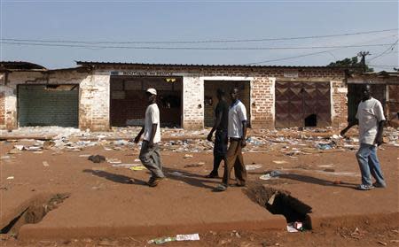 Men walk past looted stores belonging to Muslims in Combattant district in Bangui December 12, 2013. REUTERS/Emmanuel Braun