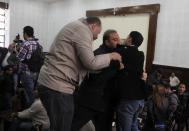 Members of the Muslim Brotherhood clash with policemen during the trial of the Brotherhood leaders in a courtroom in Cairo December 11, 2013. Prominent members of the Brotherhood were arrested in a state crackdown on the group following the army overthrow of President Mohamed Mursi and are charged with perpetrating violence during July's clashes. (REUTERS/Stringer)