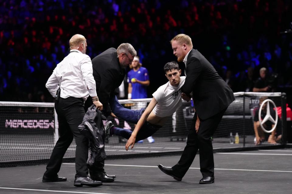 Stewards remove a protester after setting fire to the court (John Walton/PA) (PA Wire)