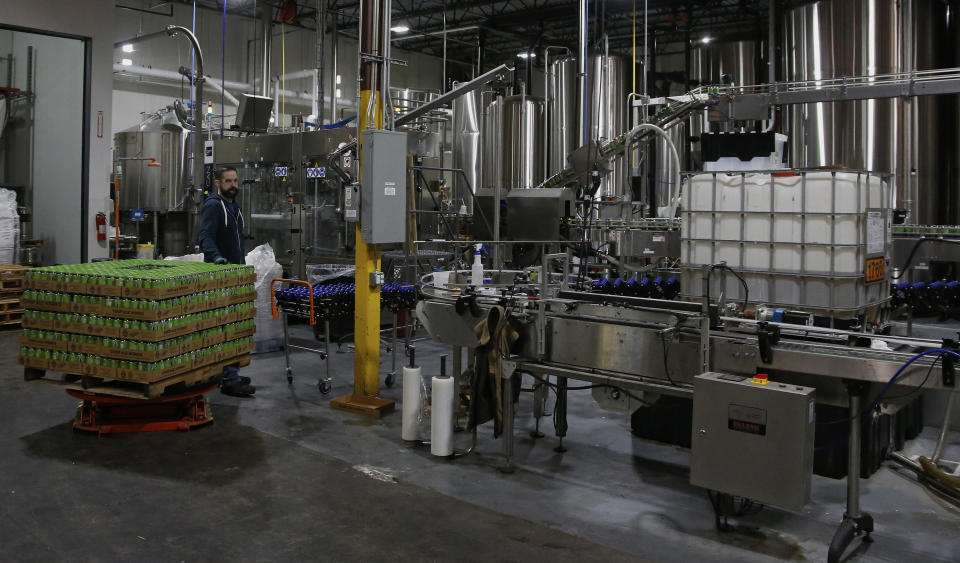Josh Yager transfers cans of F5, one of their most popular brews, from the production line at COOP Ale Works in Oklahoma City, Friday, Jan. 18, 2019. COOP Ale Works, which distributes in six states including Oklahoma and Kansas, has discontinued two of its three 3.2 percent brews. (AP Photo/Sue Ogrocki)