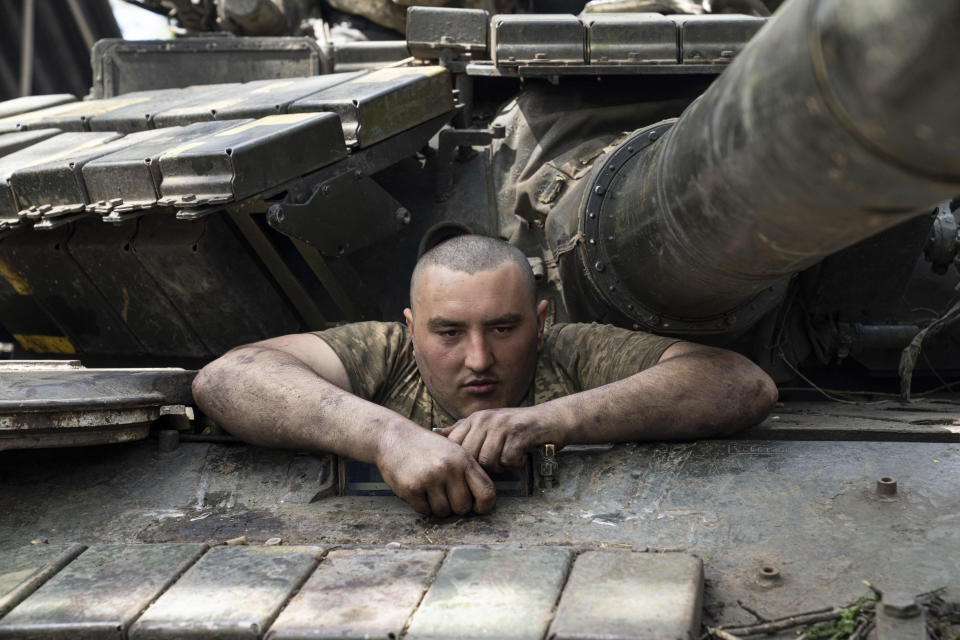 A Ukrainian serviceman enters a tank during the repair works after fighting against Russian forces in Donetsk region, eastern Ukraine, Wednesday, April 27, 2022. (AP Photo/Evgeniy Maloletka)